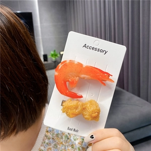 Detailed view of creative shrimp and fried chicken nuggets hair clips on accessory card