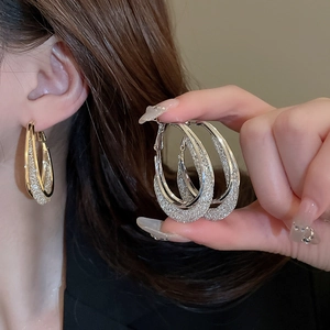 Detail of metal mesh hoop earrings with sparkling glitter texture in gold and silver