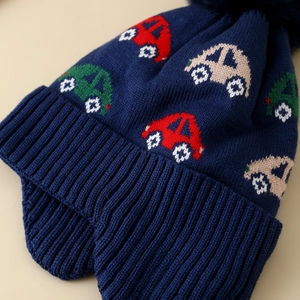 Detailaufnahme einer dunkelblauen Strickmütze mit bunten Cartoon-Auto-Mustern