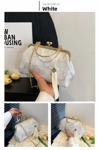 Detail of white peony embroidery on shell bag with golden frame and silk tassels