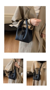 Detail of black lychee grain leather bucket bag featuring a belt lock and handle