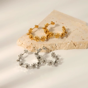 Vue détaillée de boucles d'oreilles fleurs en acier titane coloris doré et argenté