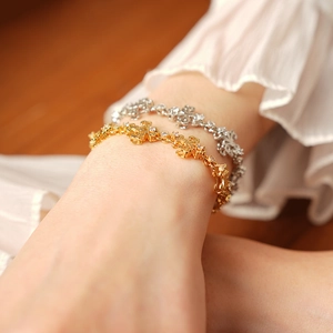 Détail des bracelets vintage iris en or et argent avec motifs de pétales ajourés