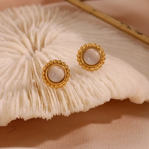 Detail of 18K gold-plated sunburst earrings featuring grey cat-eye stones on silk