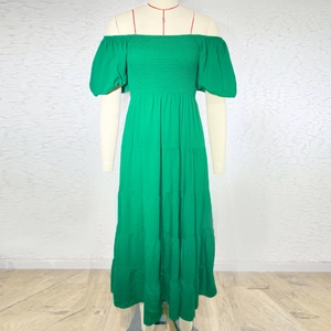 Detailed view of the layered tiered skirt and bubble sleeves on the green maxi dress