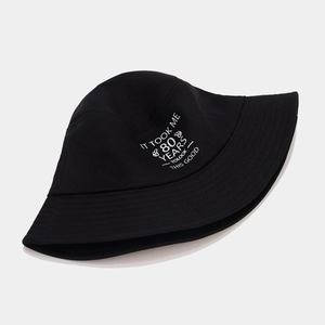 Detail of embroidered 'IT TOOK ME 80 YEARS TO LOOK THIS GOOD' text on a black cotton bucket hat