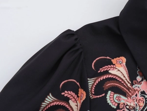Detail of floral ethnic print on shoulder of black long sleeve chiffon blouse