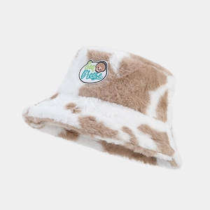 Close-up of plush cow print bucket hat featuring Sea Breeze shell embroidery detail