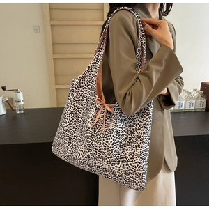 Close-up of leopard print shoulder bag featuring textured fabric and side knot detail