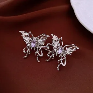 Boucles d'oreilles papillon en métal liquide et pierres violettes sur velours