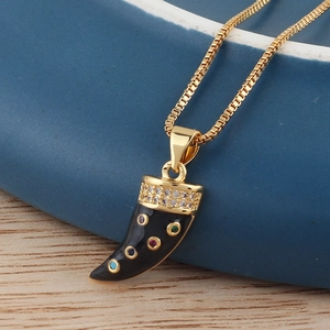 Close-up of golden horn pendant featuring black enamel and colorful zircon stone inlay