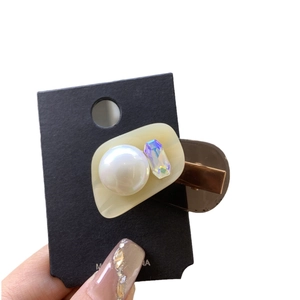 Elegant cream acetate hair clip with pearls and iridescent crystal on a metal duckbill clip