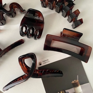 Minimalist amber tortoiseshell hair claws in geometric patterns for elegant styling