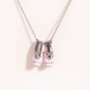 Detail shot of mini pink enamel ballet shoe pendant on a delicate silver link chain