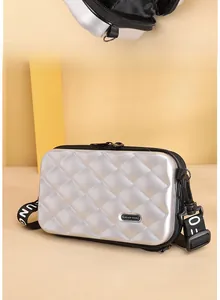 Detail view of silver mini hardshell crossbody bag with textured rhombic pattern