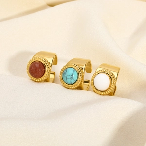 Three gold adjustable rings with turquoise and lapis gemstones on silk background