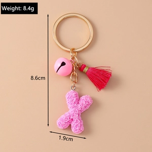Close-up of pink rose letter X keychain with tassel and bell showing 8.6cm height detail