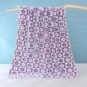 Detail of soft purple and white checkered flower pattern towel on a wooden hanger