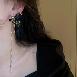 Detail of silver needle butterfly tassel earrings with black accents on a female model