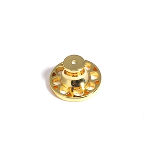 Macro detail of golden metal earring lifters with ornate decorative filigree edges
