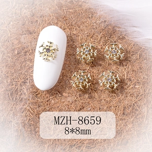 Detail of a gold alloy Christmas snowflake nail art charm with a sparkling rhinestone inlay