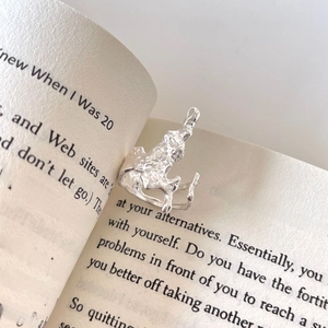 Minimalist irregular 925 sterling silver open ring with molten lava texture on a book