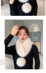 Detail of white faux fur scarf with large pom-pom pendant and fluffy elegant texture