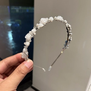 Detail of silver headband with white resin roses, imitation pearls and shiny rhinestones