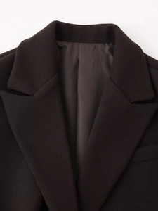 Detail view of the notch lapel and dark inner lining of this brown wool blend coat