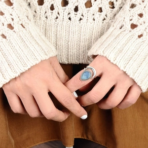 Retro silver ring with teardrop blue stone and crescent moon details on finger