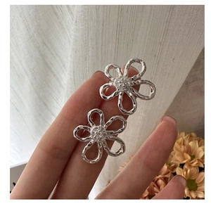 Detailed close-up of S925 silver flower stud earrings featuring shimmering cubic zirconia