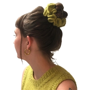 Green crochet ruffled scrunchie hair accessory shown on an elegant updo hairstyle