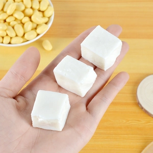 Macro shot of three miniature white tofu cube models held in palm for dollhouse decor