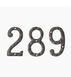 Macro detail of vintage cast iron house numbers 289 with rustic hammered texture