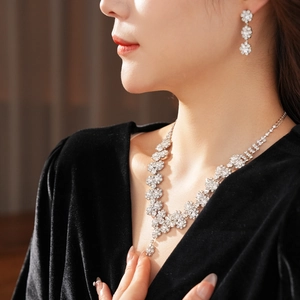 Detail shot of silver sunflower jewelry set with sparkling rhinestones worn by a model