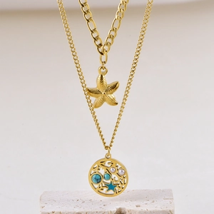 Details einer goldenen Schichtkette mit Seestern-Anhänger und durchbrochenem Perlen-Charm