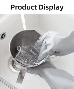 Close-up of a wire dishcloth cleaning a stainless steel cup under running water