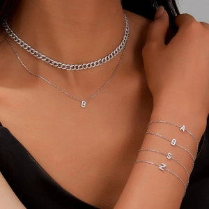 Close-up of silver Cuban link chain and zircon alphabet pendant necklace for women