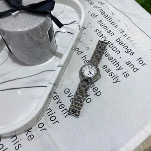 Montre en acier argenté avec cadran romain blanc sur un fond élégant en lin naturel
