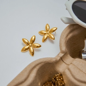 Detail showing elegant gold floral earrings with a polished finish and five-petal design