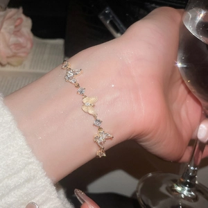 Detailed view of a gold-plated bracelet featuring zircon butterflies and opal wings