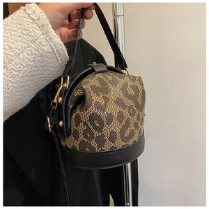 Detail of leopard print bucket bag with black PU leather trim and gold metal hardware