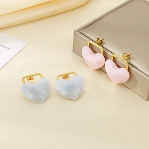 Detailed macro shot of 18K gold-plated heart earrings with marble texture in pink and blue