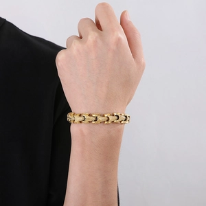 Detail of masculine golden stainless steel keel chain bracelet on male wrist