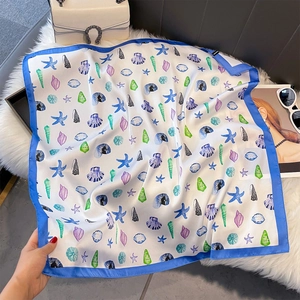 Détail macro du foulard en soie aux motifs marins et bordure bleue éclatante