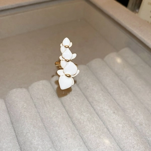 Elegant white petal open ring with gold accents displayed on a gray velvet tray