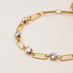 Macro shot of gold paperclip chain bracelet featuring sparkling round cubic zirconia accents