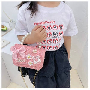 Detailed view of pink tweed kids handbag with pearl handle and camellia flower decor