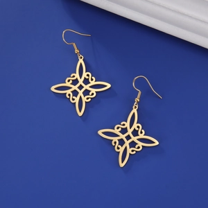 Nahaufnahme der goldenen Edelstahl Hexenknoten-Ohrringe auf dunkelblauem Hintergrund