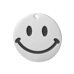 Detail of round stainless steel pendant with black engraved smiley face on white background